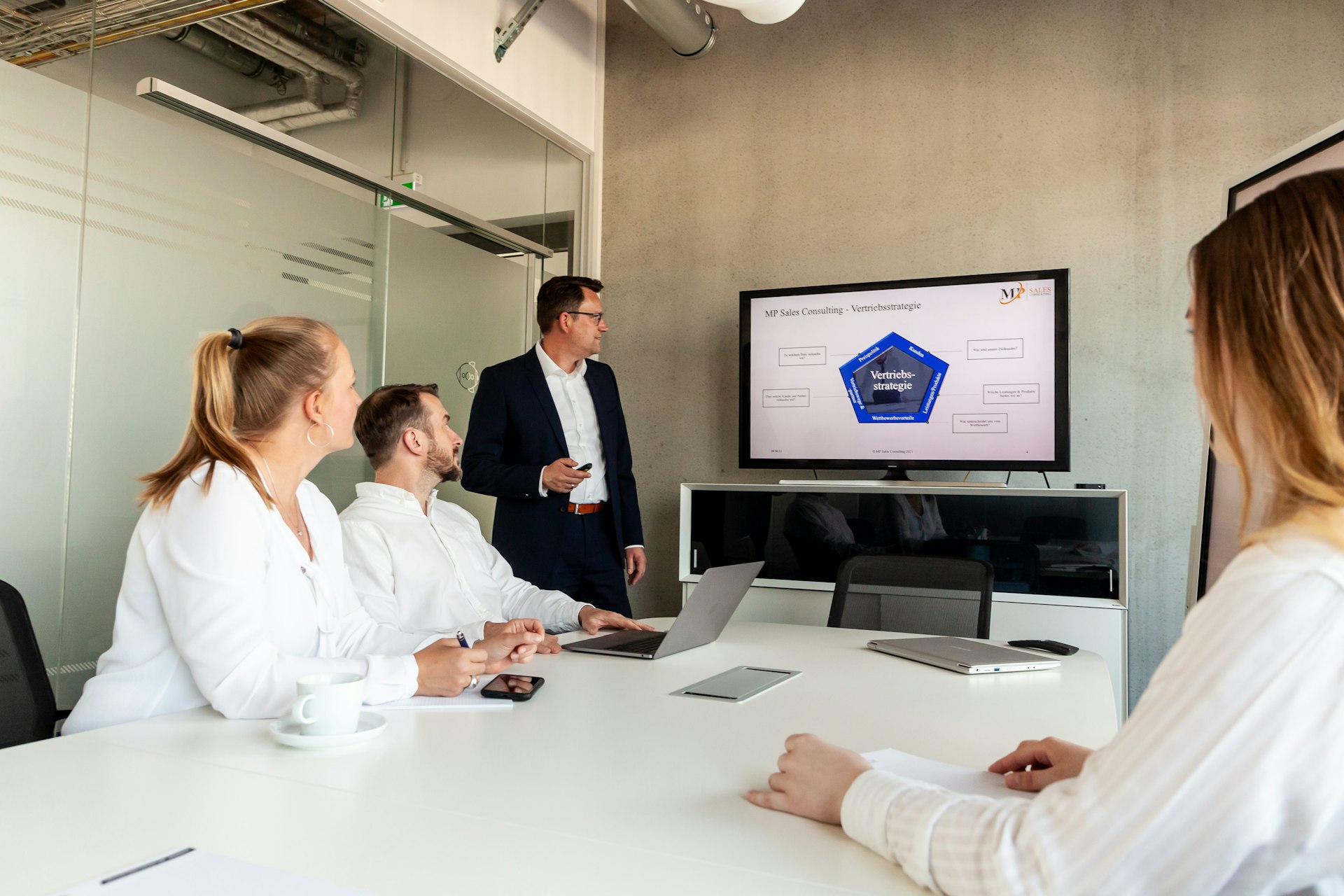 A presenter leading a business meeting with colleagues in an office